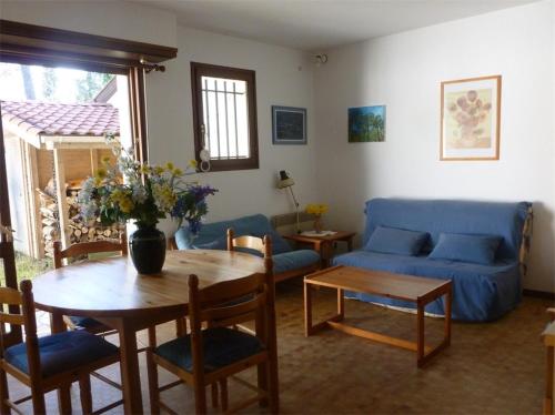 un salon avec un canapé bleu et une table dans l'établissement Réf 210 Seignosse Océan, Villa Patio Classée 3 étoiles au Calme, Proche de la plage et des commerces, à Seignosse