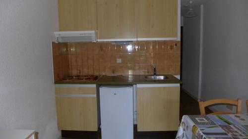 a small kitchen with a sink and a refrigerator at Réf 434 Seignosse océan, appartement classé 2 étoiles, accès direct à l'océan et place de parking privée, 4 personnes in Seignosse