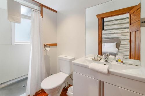 a bathroom with a toilet and a sink and a mirror at Lakes Lodge Rotorua in Rotorua