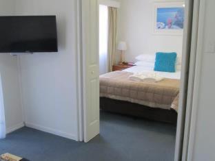 a bedroom with a bed and a flat screen tv at Costa D'Ora Holiday Apartments in Gold Coast