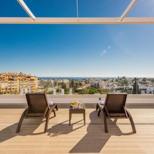 two chairs and a table on a balcony with a view at Aqua Apartments Vento, Marbella in Marbella