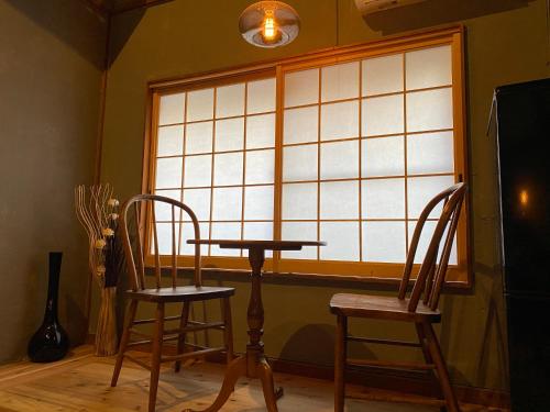 岡山的住宿－Gunjonoma Yadokari，窗前的一张桌子和两把椅子