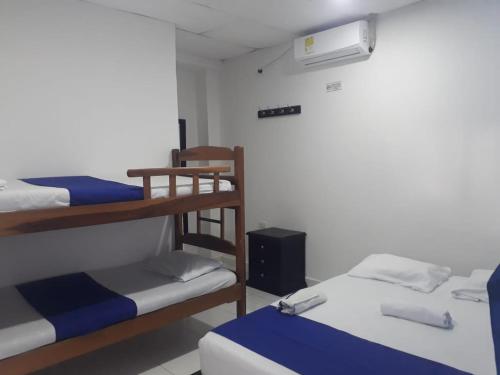 a room with two bunk beds and a air conditioner at Hotel Don Toño Tolú in Tolú