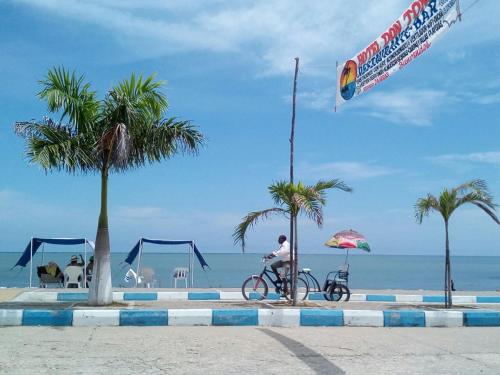 a person riding a bike on the beach with a kite at Hotel Don Toño Tolú in Tolú