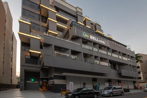 un bâtiment avec des voitures garées devant lui dans l'établissement Fengjia Hotel Bell, à Taichung