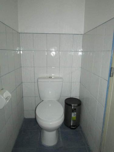 a bathroom with a white toilet and a trash can at Felipa Beach and Guesthouse - Gumamela in Dumaguete