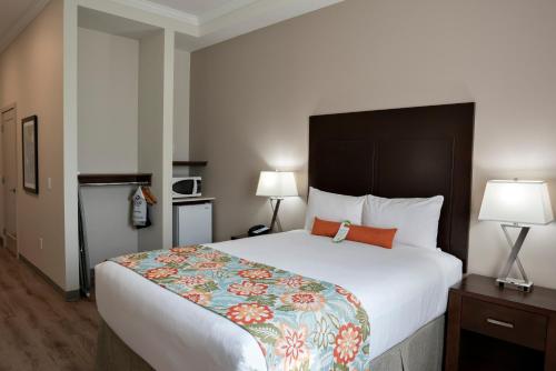 a hotel room with a large bed and two lamps at Coast Oliver Hotel in Oliver