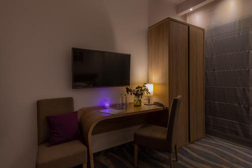 a room with a desk with two chairs and a television at Hotel Bardo in Bardo
