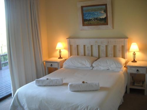 a bedroom with a white bed with two towels on it at Sandown Self-Catering in Cape St Francis