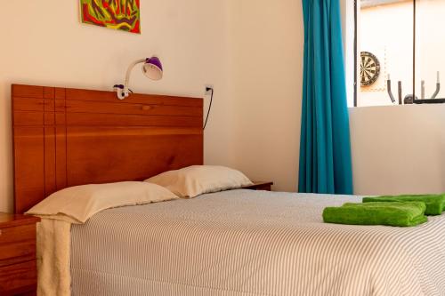 1 dormitorio con 1 cama con cabecero de madera y ventana en House in Cusco, en Cusco