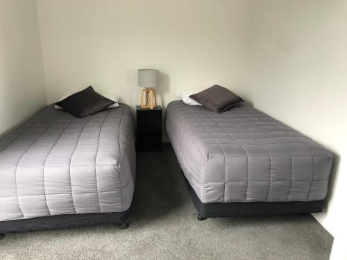 two beds sitting next to each other in a room at Nugget View Kaka Point Motels in Kaka Point