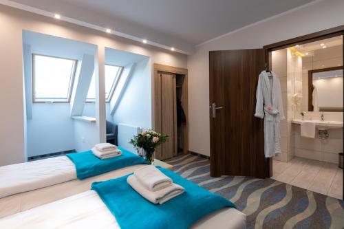 two beds in a room with a bathroom at Hotel Bardo in Bardo