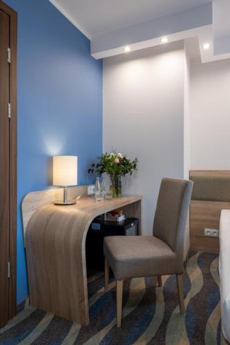 a room with a desk with a chair and a lamp at Hotel Bardo in Bardo