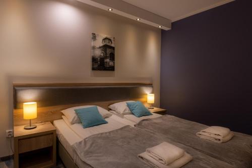 um quarto com 2 camas e almofadas azuis em Hotel Bardo em Bardo