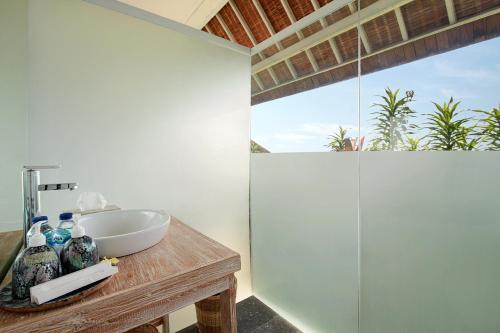 y baño con lavabo y ducha acristalada. en Kerang Bingin Beach Villa, en Uluwatu