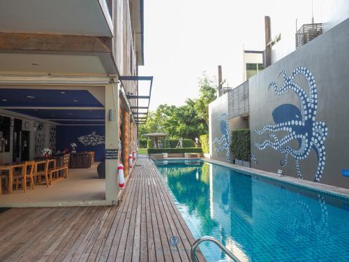 a swimming pool with a mural on the side of a building at Sea and Sea Villa Sangaroon in Ban Nam Tok