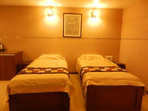 two beds in a room with lights on the wall at Brunton Heights Executive Suites in Bengaluru