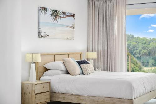 a bedroom with a bed with a view of the beach at Villa Provence Coffs Harbour in Coffs Harbour