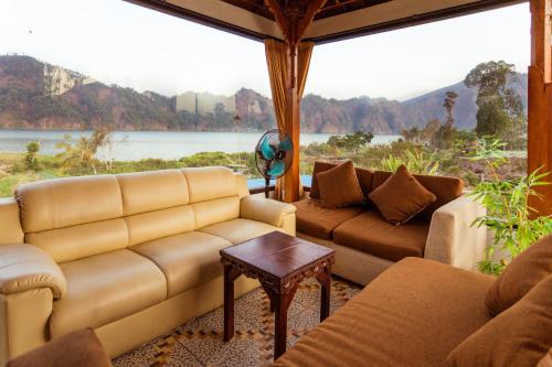 a living room with couches and a large window at Villa Jempana Kintamani in Kintamani