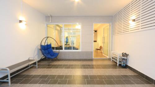 een wachtkamer met een blauwe stoel en een raam bij Airee Premier Residence in Bangkok