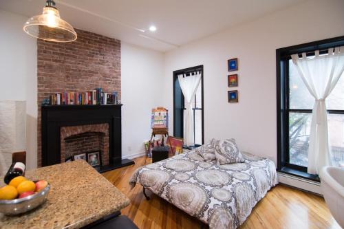 a living room with a bed and a fireplace at Historic 1869 Brownstone 15 min to NYC downtown in Jersey City