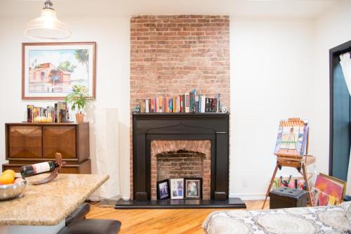 a living room with a fireplace with a brick wall at Historic 1869 Brownstone 15 min to NYC downtown in Jersey City