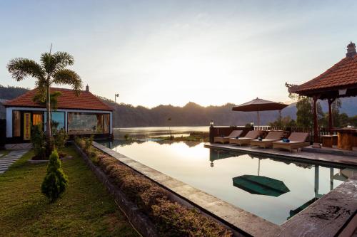 a villa with a pool with chairs and a house at Villa Jempana Kintamani in Kintamani