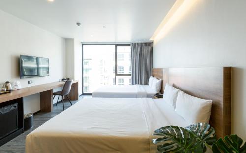 a hotel room with two beds and a television at STAY Hotel BKK - SHA PLUS in Bangkok