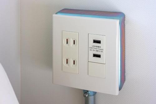 a white light switch on a wall at &AND HOSTEL MINAMISENJU in Tokyo