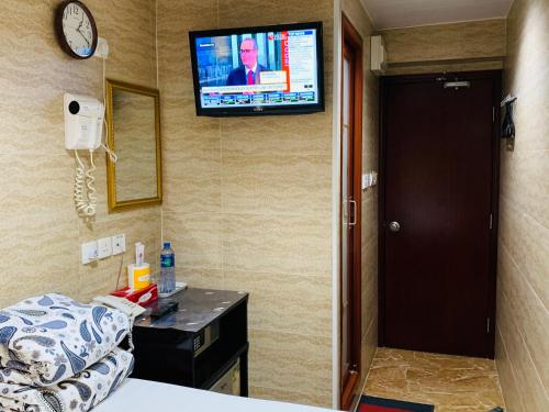 a room with a bed and a television on the wall at Sleep Inn in Hong Kong