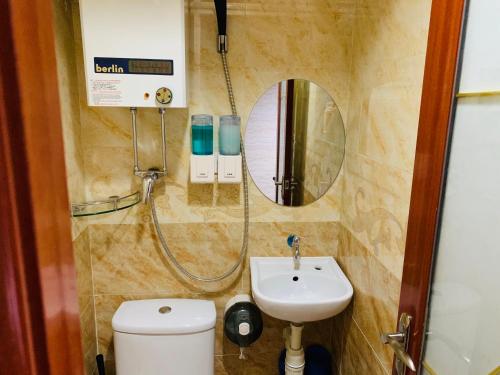 a bathroom with a sink and a mirror and a toilet at Sleep Inn in Hong Kong
