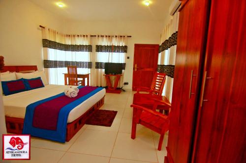 a bedroom with a bed and a table and chairs at Athkandura Hotel in Habarana