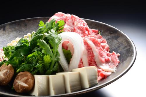 a plate of food with meat and vegetables on a table at Balinese onsen ryokan Hakone Airu in Hakone