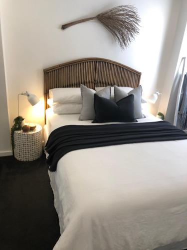 a bedroom with a large bed with white sheets and pillows at Oceanview Kiama Luxury Holiday Accommodation in Kiama