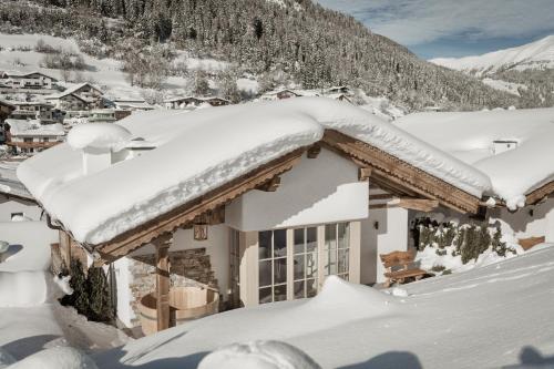 a house covered in snow on a mountain at Hüttendorf Ladizium in Ladis