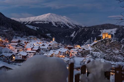 a town covered in snow at night with a snow covered mountain at Hüttendorf Ladizium in Ladis