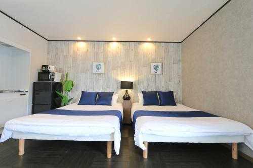 two beds sitting in a room with at Liz5 Guest House Liz Nakazakicho in Osaka