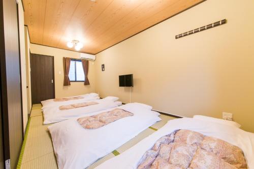 Zimmer mit 4 Betten in einem Zimmer in der Unterkunft JAPANING Senkyu in Kyoto