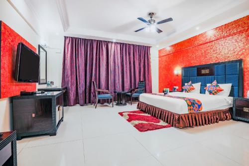 a bedroom with a king sized bed and a flat screen tv at FabHotel Royal Mirage With Pool & GYM, Candolim Beach in Candolim