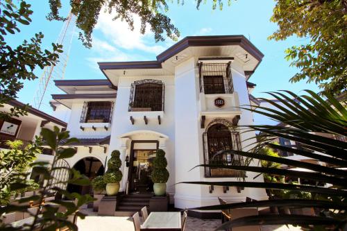 uma casa branca com uma escada em frente em The Bourke Hotel em Davao