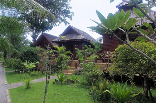 a house with a garden in front of it at Thai House Beach Resort in Ko Lanta