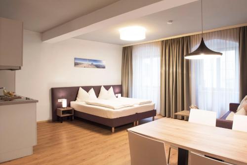 Daxburg Apartments في إنسبروك: غرفة الفندق بسرير وطاولة