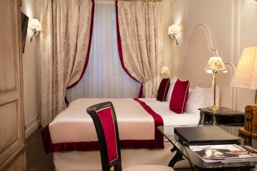a hotel room with a bed and a desk at Hotel Residence Henri IV in Paris