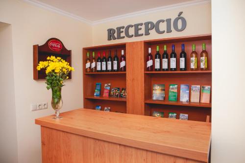 a bar with a vase of flowers on a counter at King Arthur Panzió in Baja