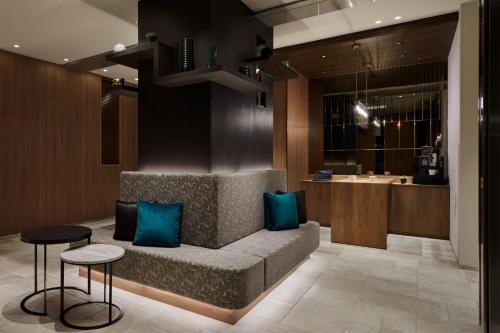 a lobby with a couch with two blue pillows at the b akasaka-mitsuke in Tokyo
