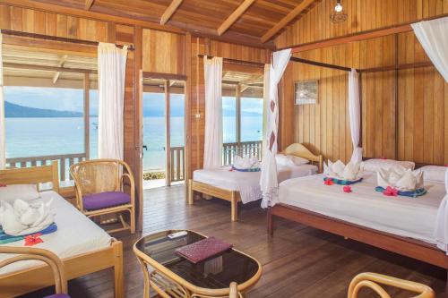 a bedroom with two beds and a view of the ocean at Onong Resort in Bunaken