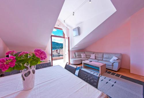 a living room with a couch and a vase with flowers at MalAna in Zaton