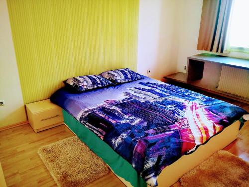 ein Schlafzimmer mit einem Bett mit einer bunten Decke in der Unterkunft Relaxing & Welcome Apartment, Ared, UTA - All Inclusive in Arad