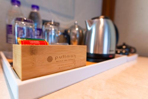 a wooden box on a counter with a tea kettle at Pullman Huizhou Kaisa in Huizhou