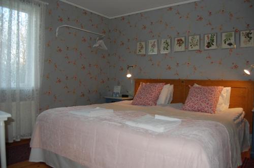 a bedroom with a large bed with red wallpaper at STF Vickleby Bo Pensionat in Färjestaden